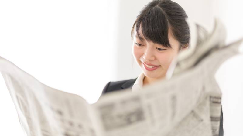 女性が経済についての新聞記事を読んでいる様子