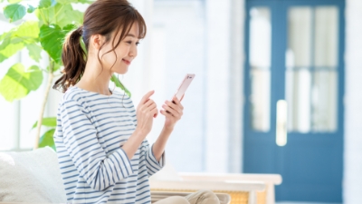 女性がスマホで口座開設の手続きをしている様子