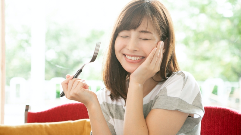 女性が新メニューを食べて喜んでいる様子