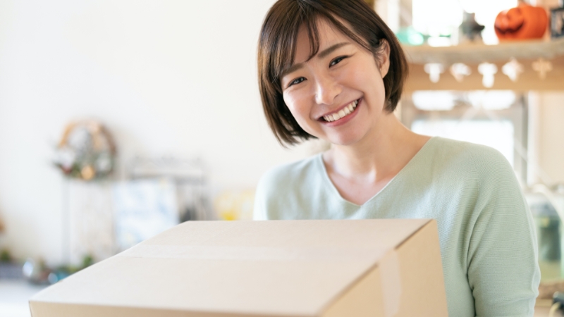 女性が株主優待制度を利用してプレゼントを受け取る様子